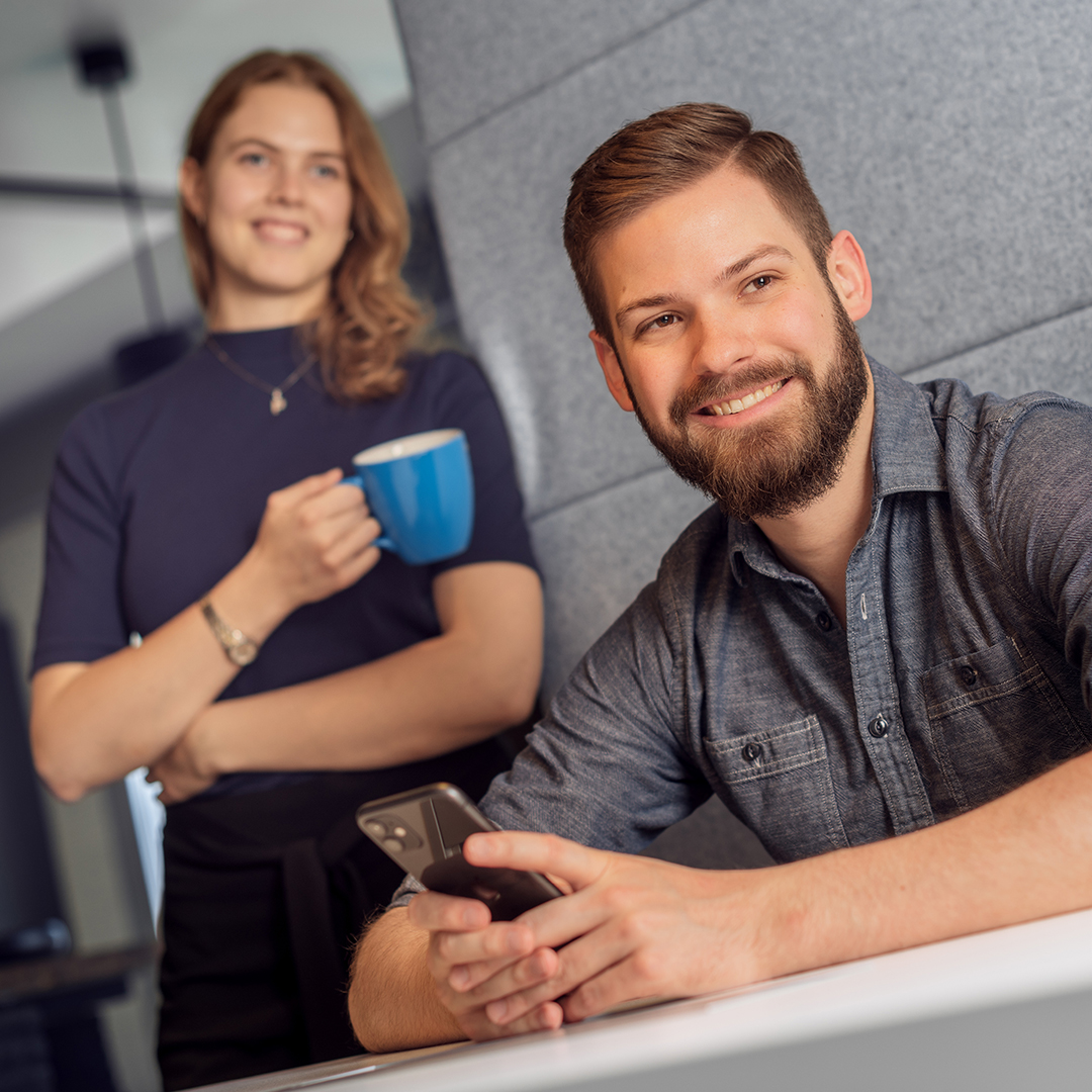 Ein Mann und eine Frau, die in die Kamera lächeln