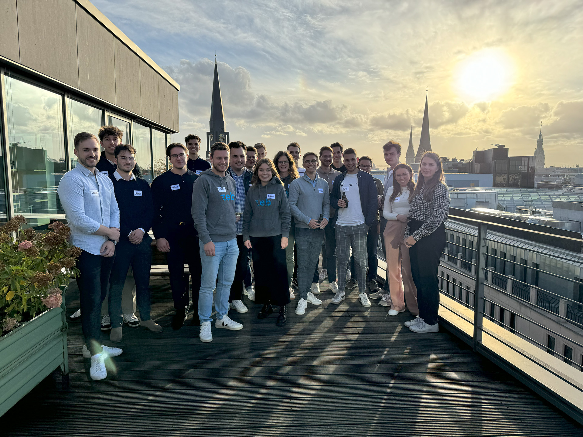 Eine Gruppe Studierender steht auf einer Terrasse über den Dächern Hamburgs.