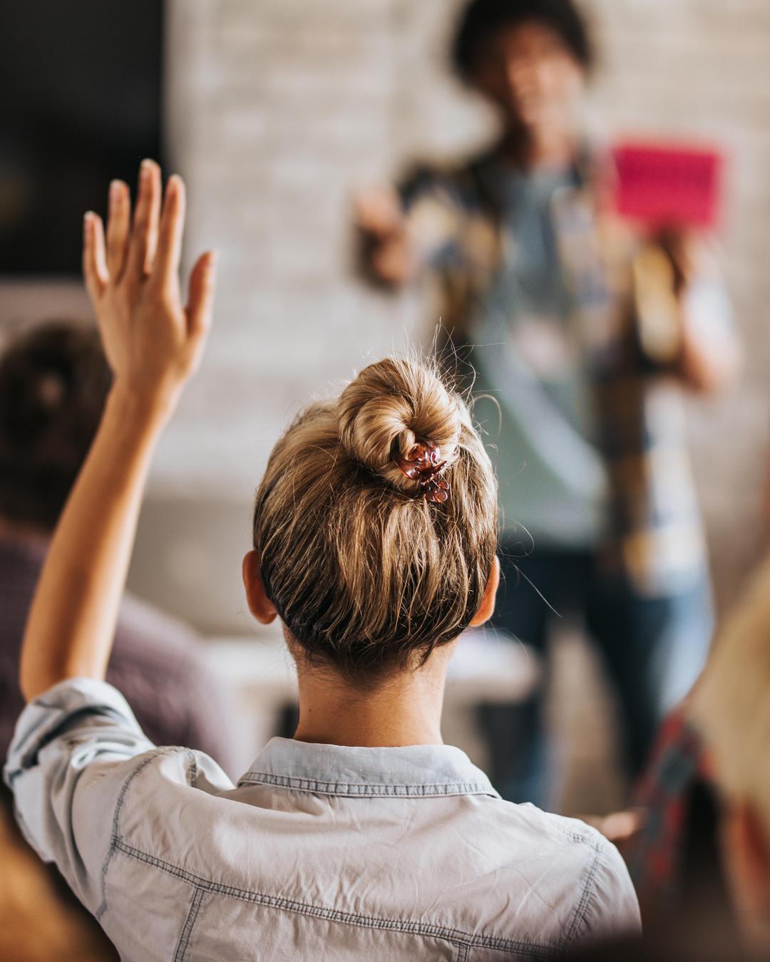 A woman raises her left hand to signal