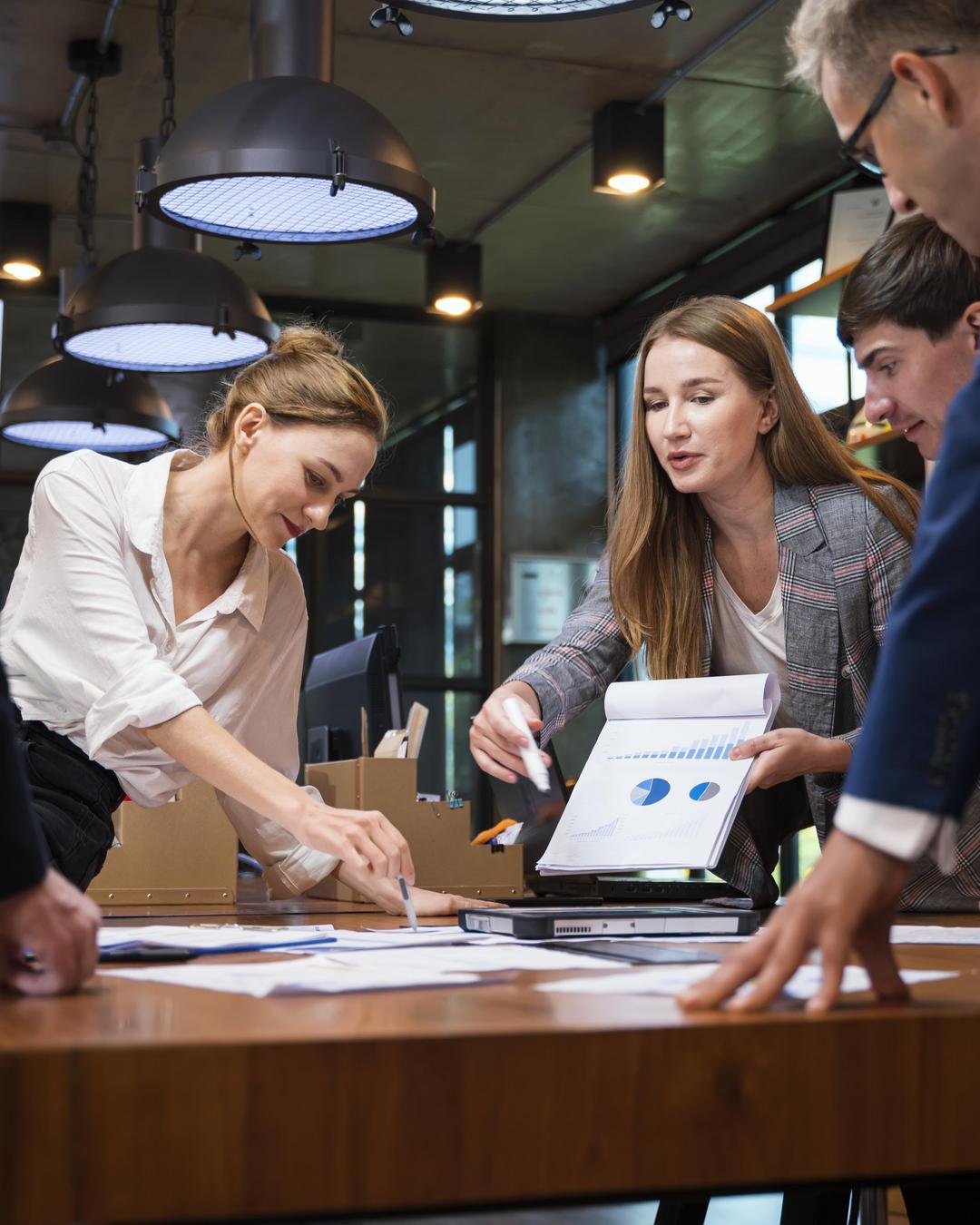 A group stands around a table and discusses.