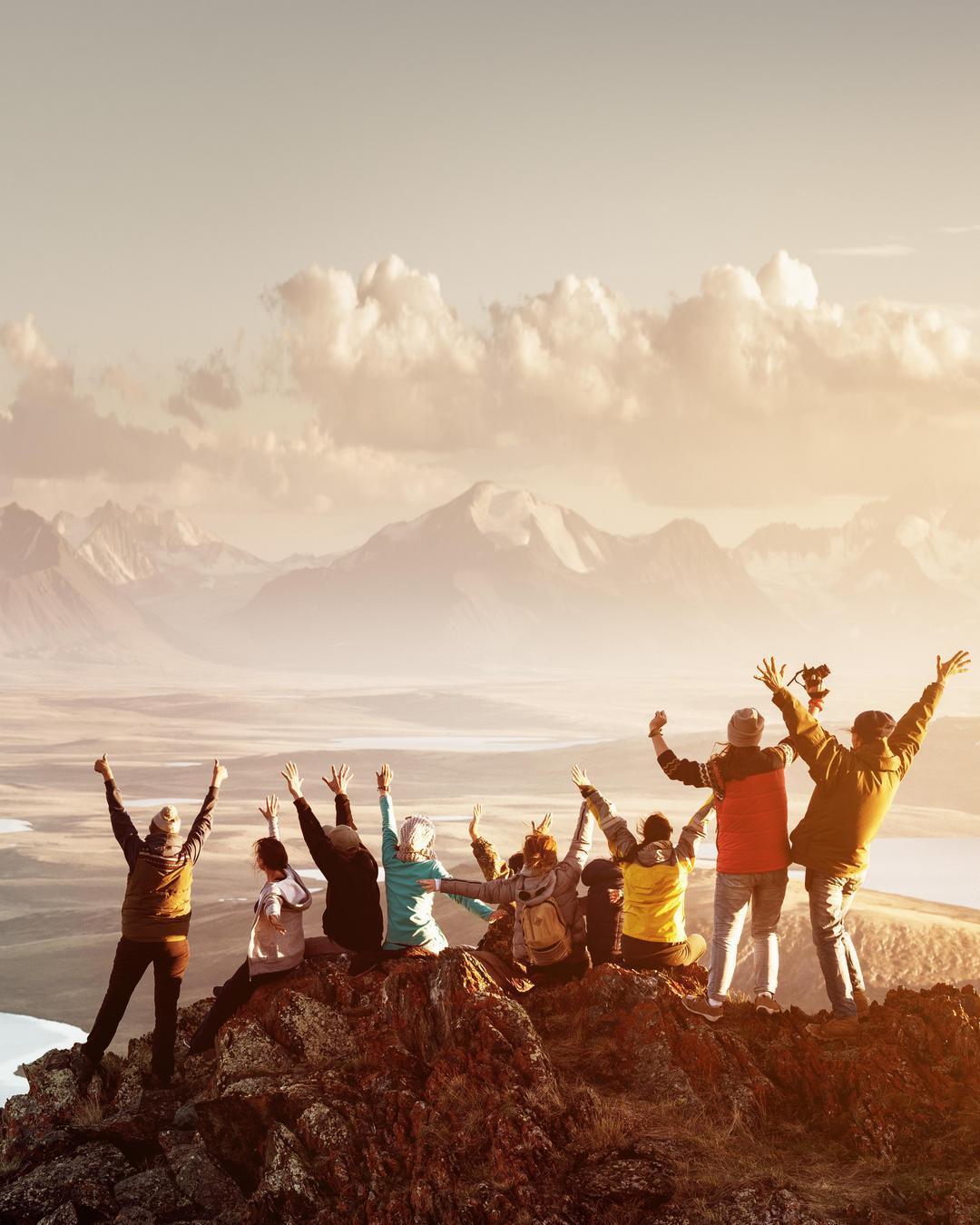 A group on a mountain summit enjoying themselves