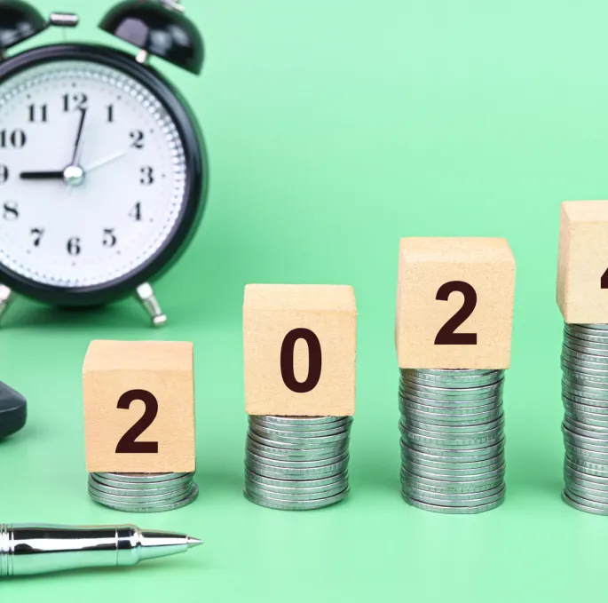 A stack of coins with numbers on blocks and a pen
