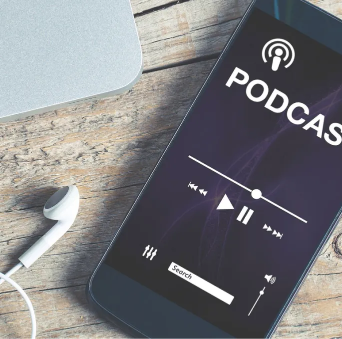 A smartphone with plugged in headphones, on which a podcast is playing