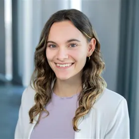 Eine Frau, die in die Kamera lächelt