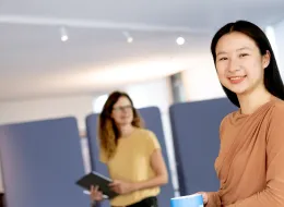 Zwei Frauen sind zu sehen, eine trägt ein Tablet.