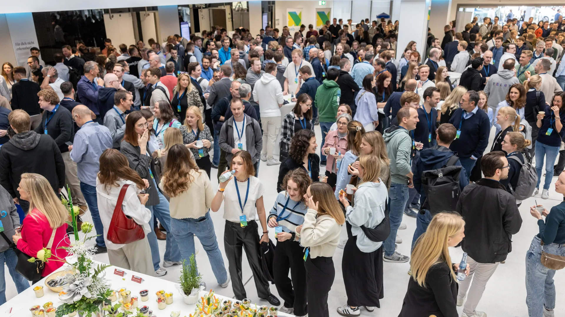 A large group of people in the conference hall's lobby