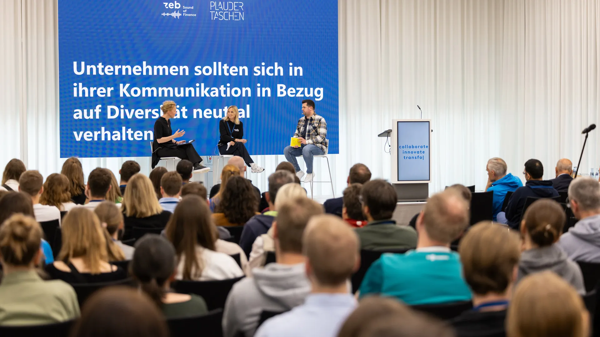 Eine Gruppe von Menschen, die auf einer Bühne sitzen