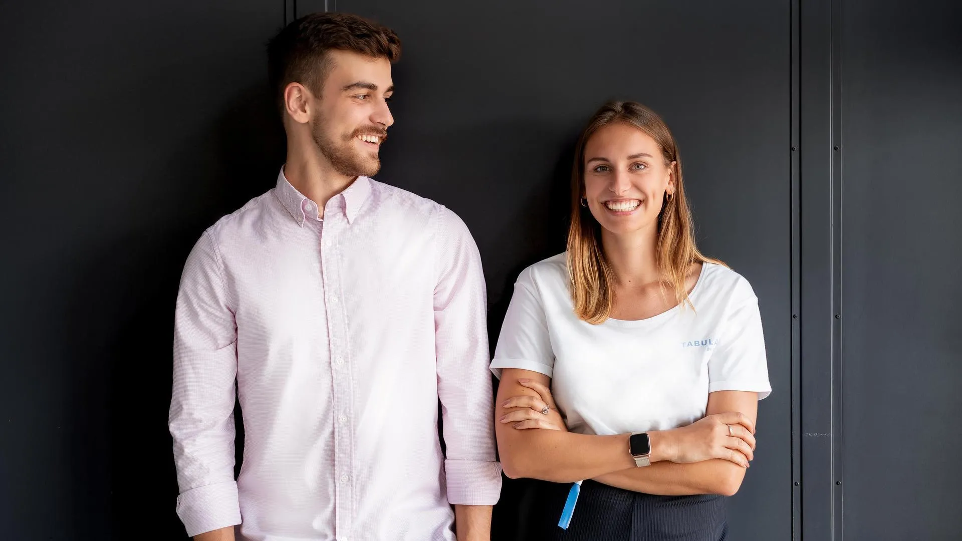 Ein Mann und eine Frau lehnen an einer Wand.