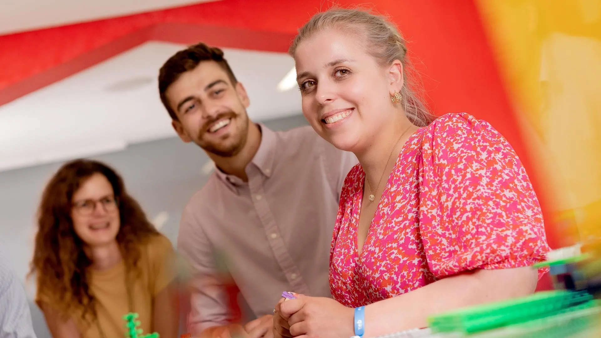 Eine Gruppe von Menschen, die an einem Tisch mit Bausteinen sitzen