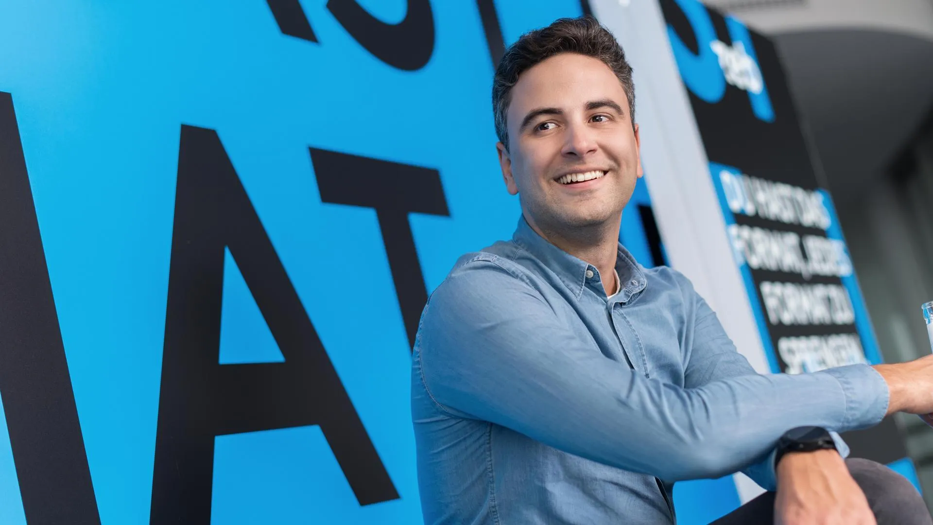 Ein Mann, der mit verschränkten Armen lächelt