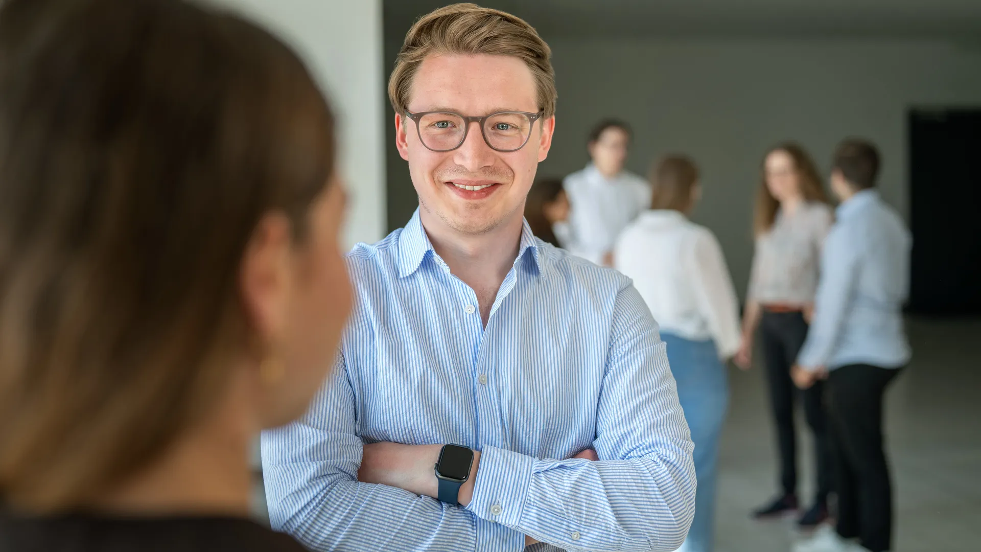 Ein Mann mit Brille und Smartwatch lächelt