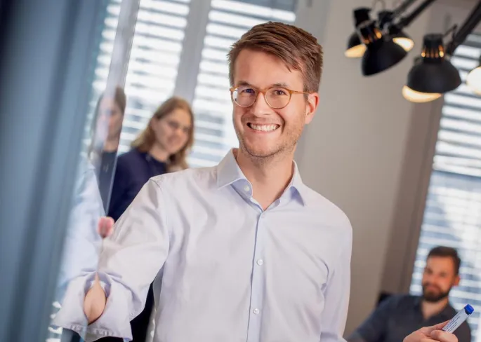 Ein Mann steht vor einer Glaswand