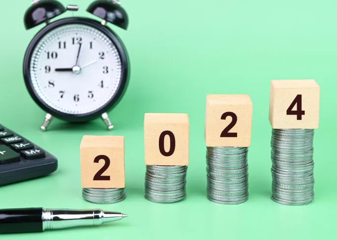 A stack of coins with numbers on blocks and a pen