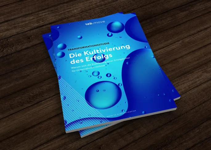 A blue book lies on a wooden desk.