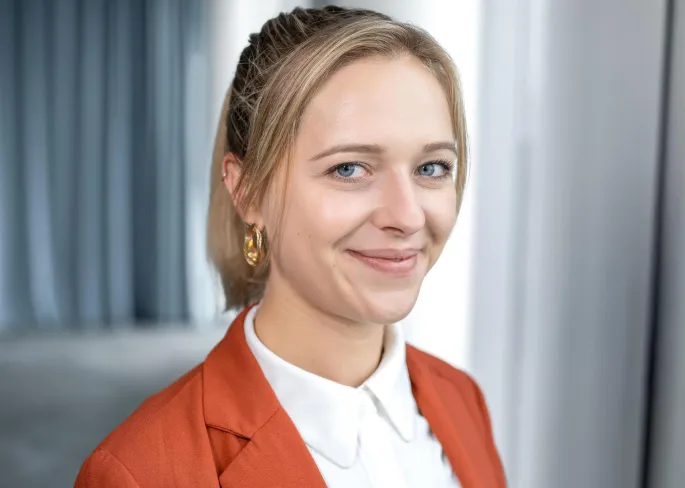 Eine Frau, die in die Kamera lächelt