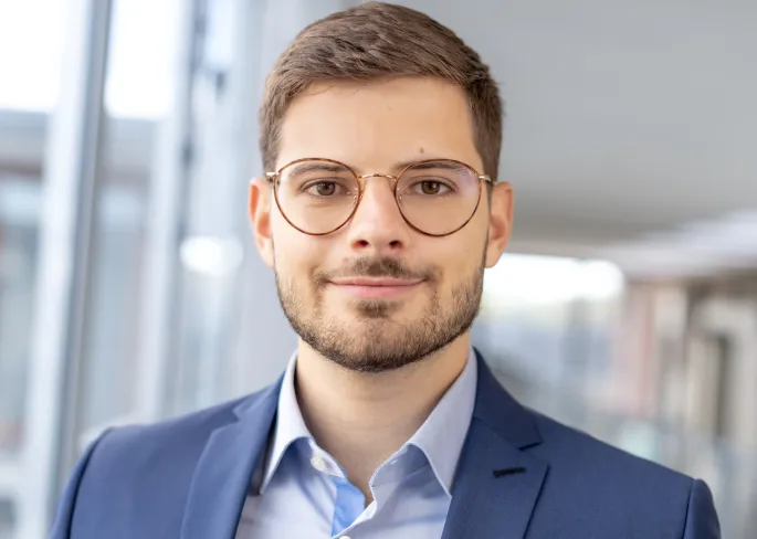 a man wearing glasses and a suit