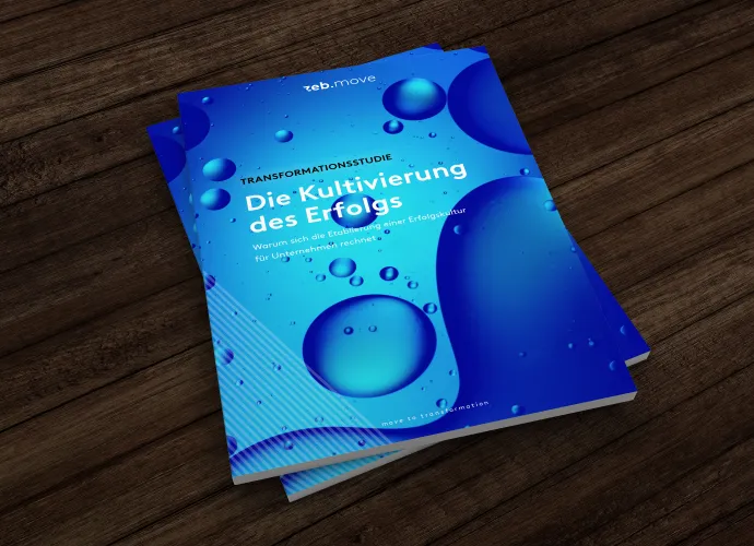 A blue book lies on a wooden desk.