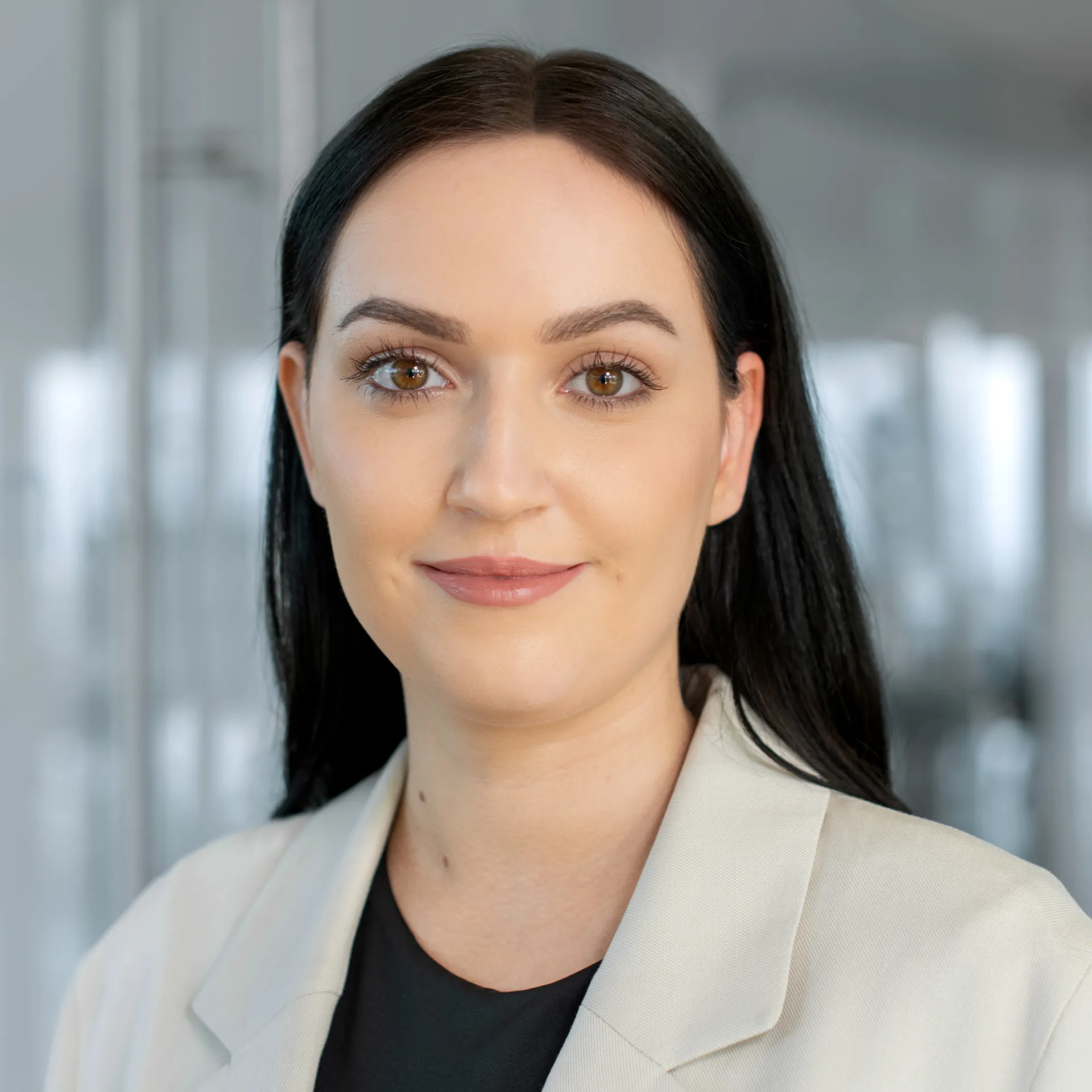 a woman with long black hair wearing a white jacket