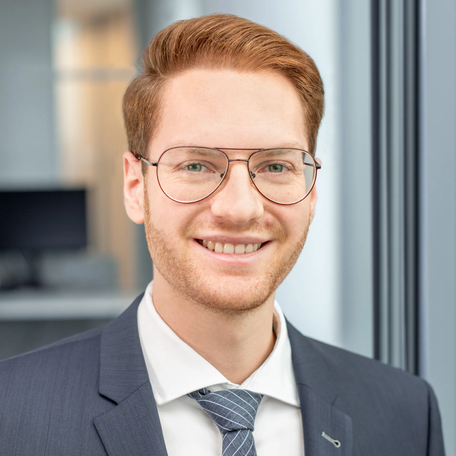 a man wearing glasses and a suit