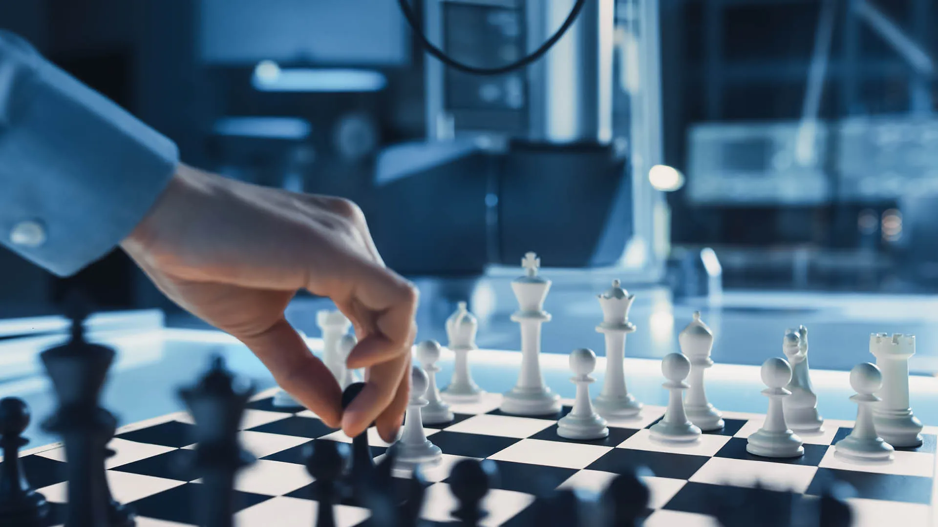 a hand moving a chess board