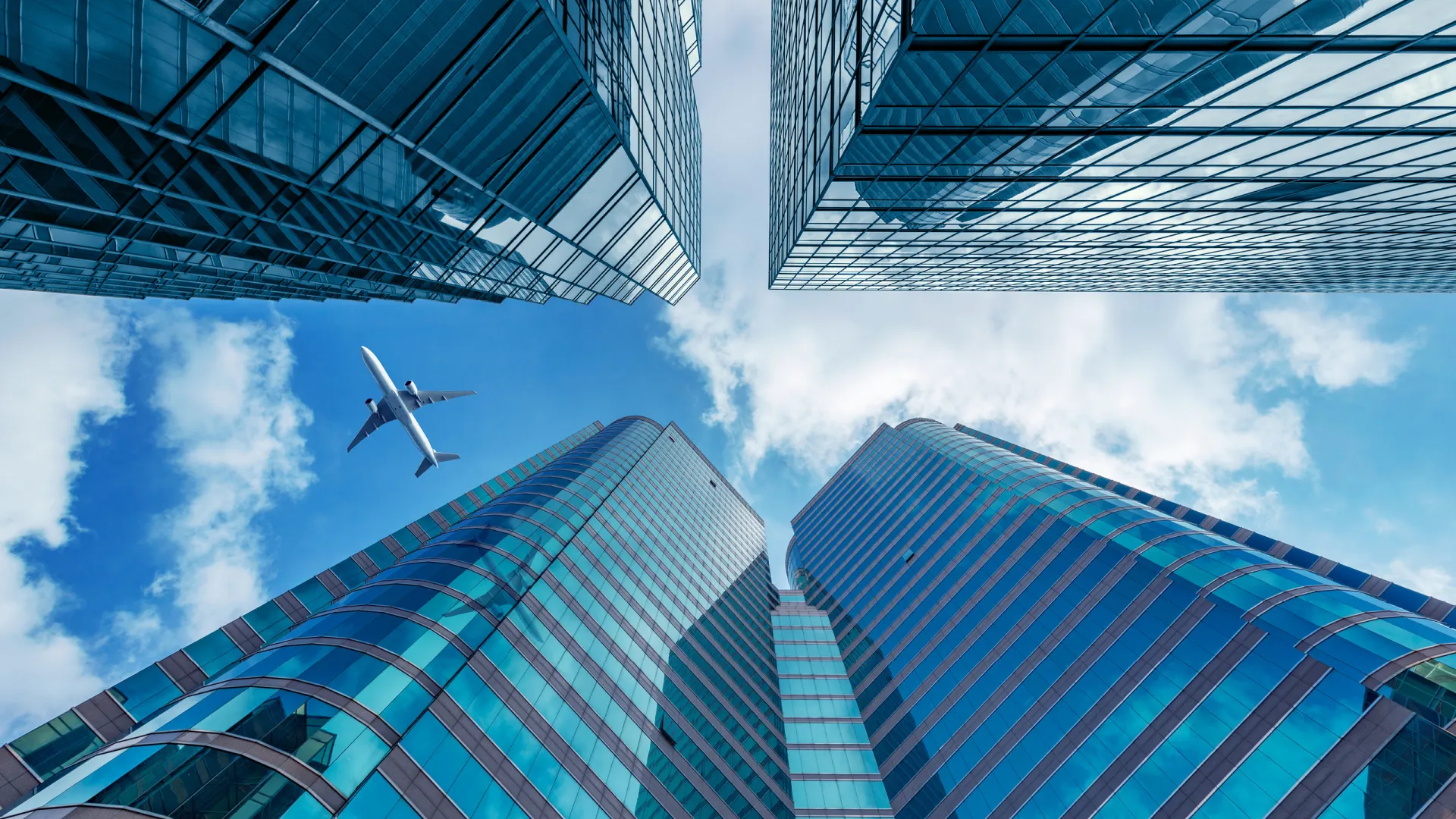 An airplane flying over tall buildings. 