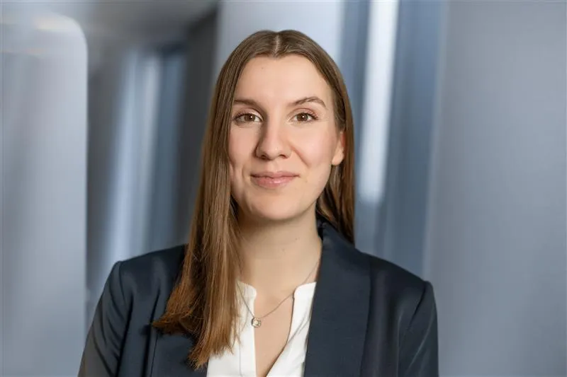 A woman with long hair wearing a suit.