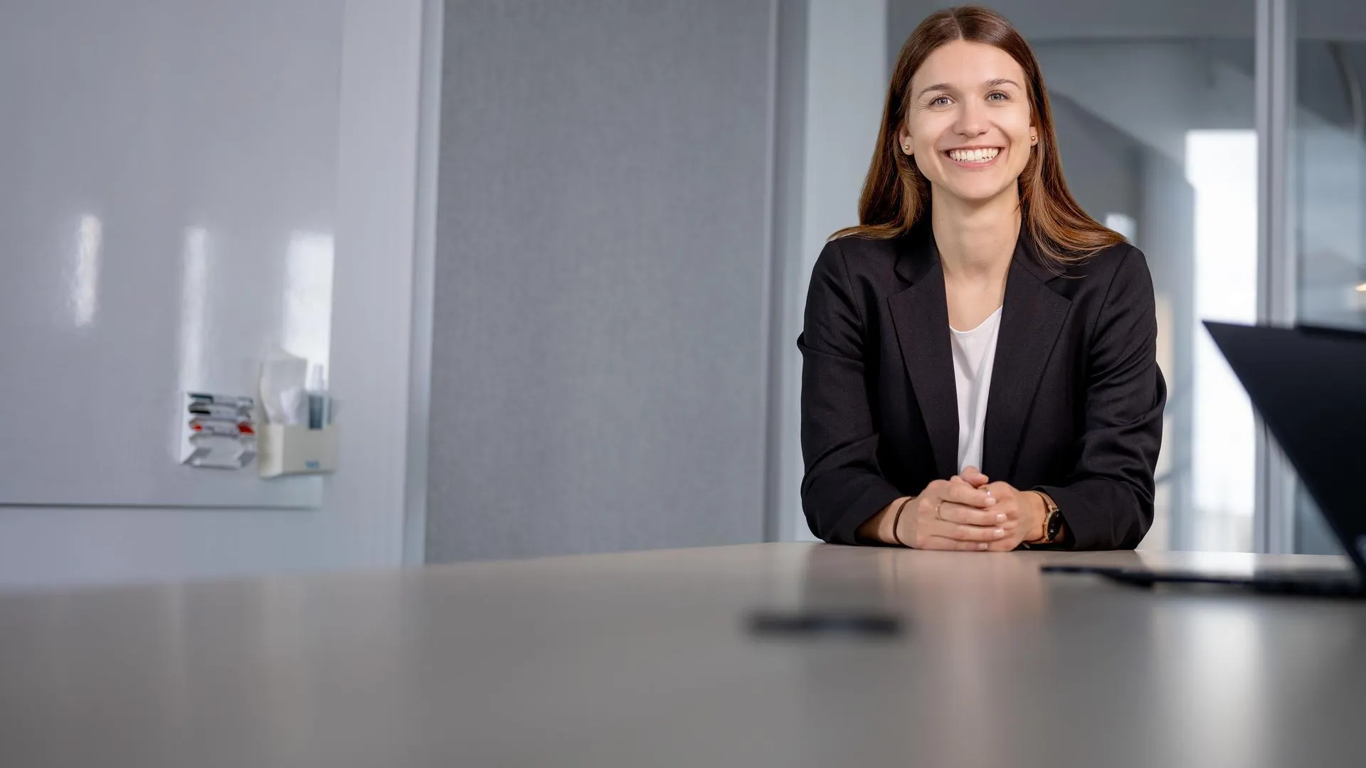 Eine Frau, die lächelnd an einem Tisch sitzt