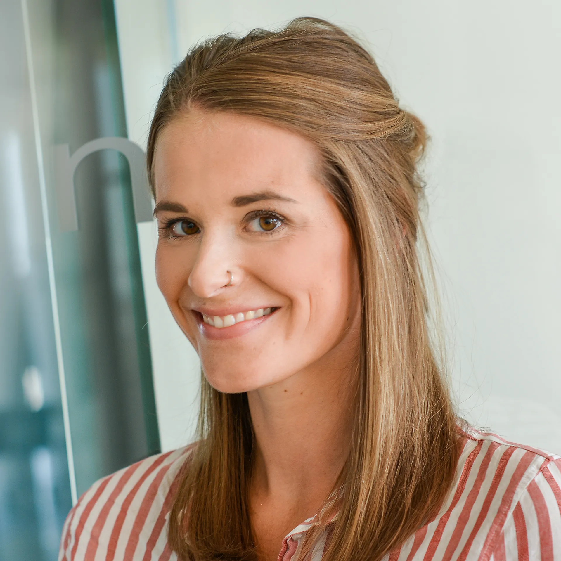 Eine Frau, die in die Kamera lächelt