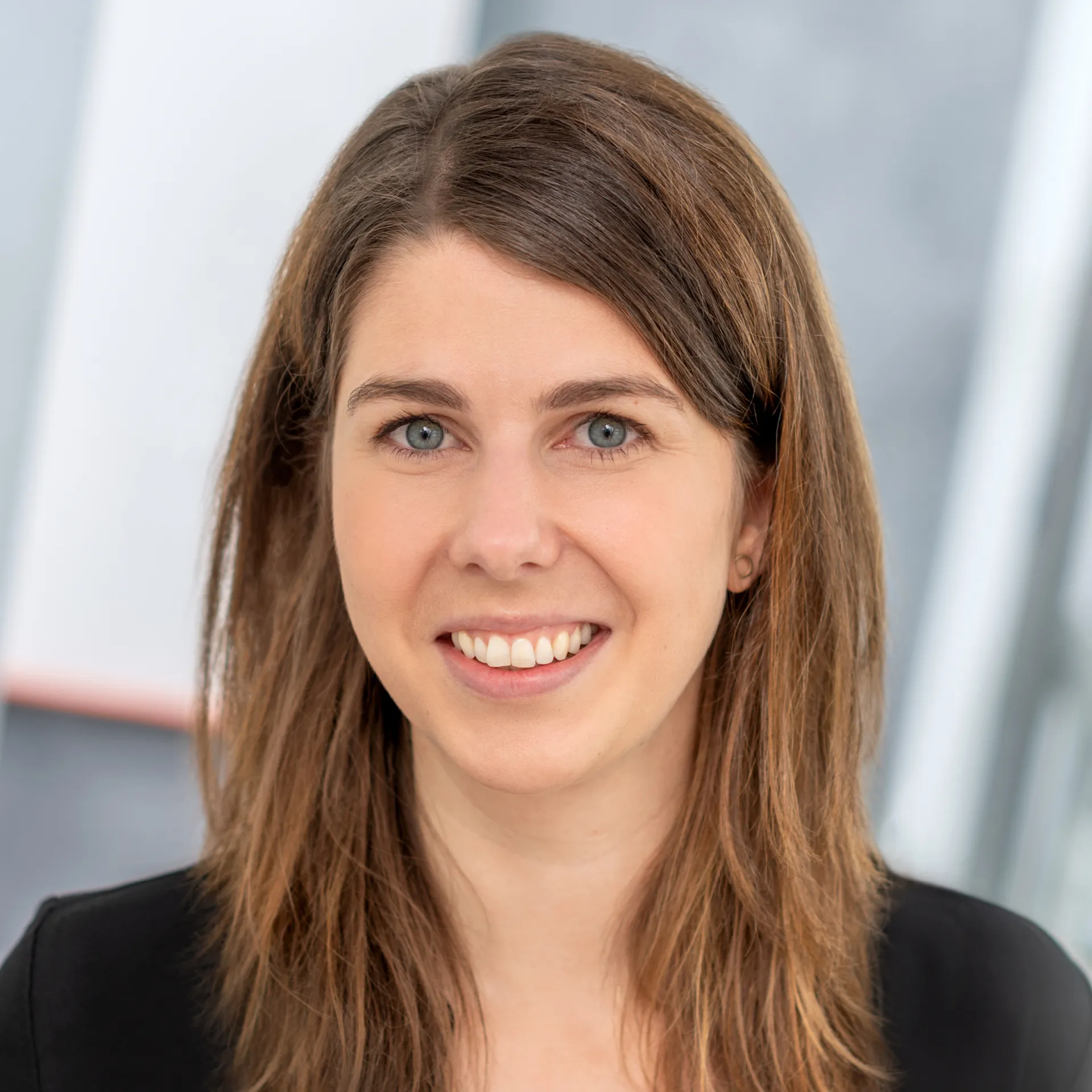 Eine Frau, die in die Kamera lächelt