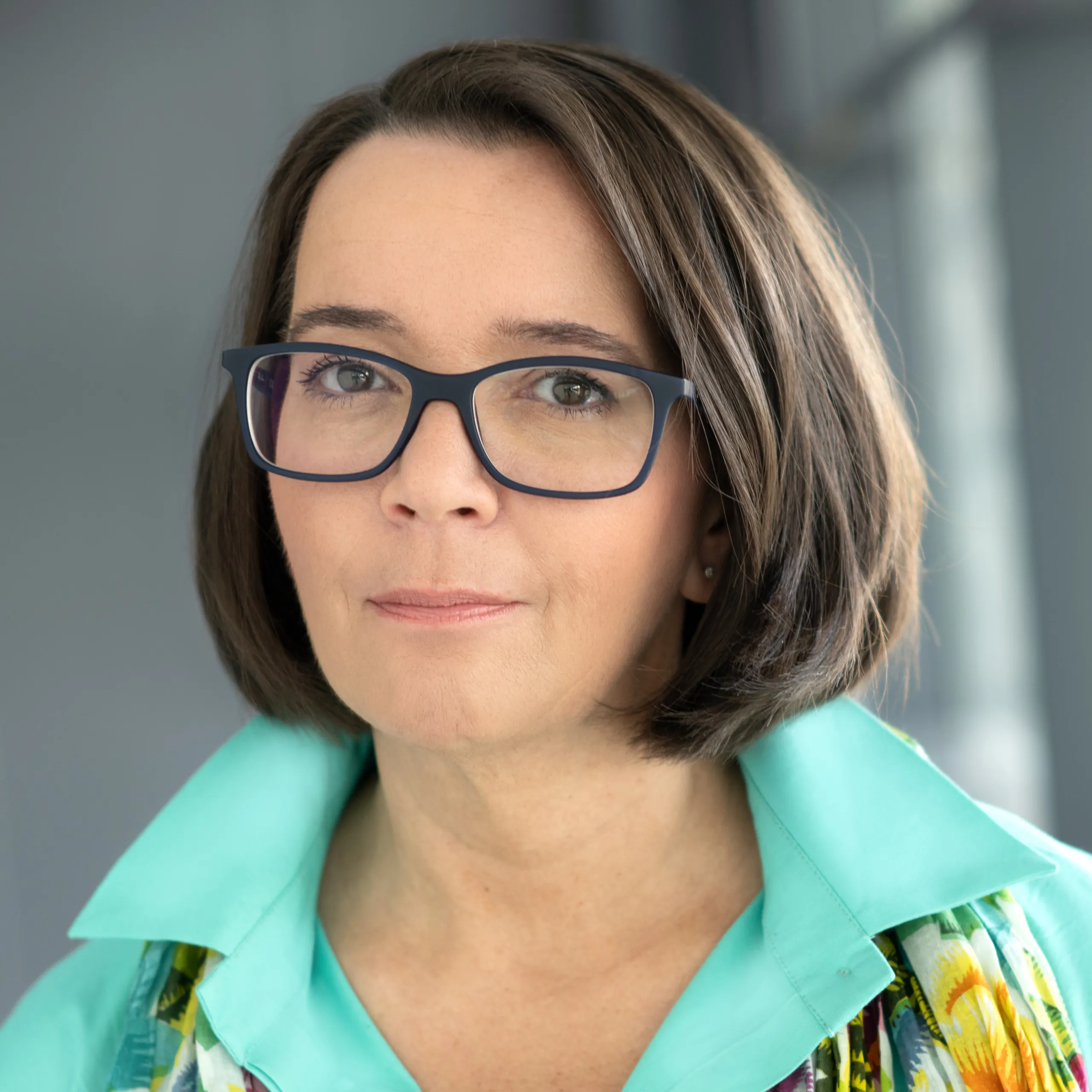 A woman is smiling into a camera.