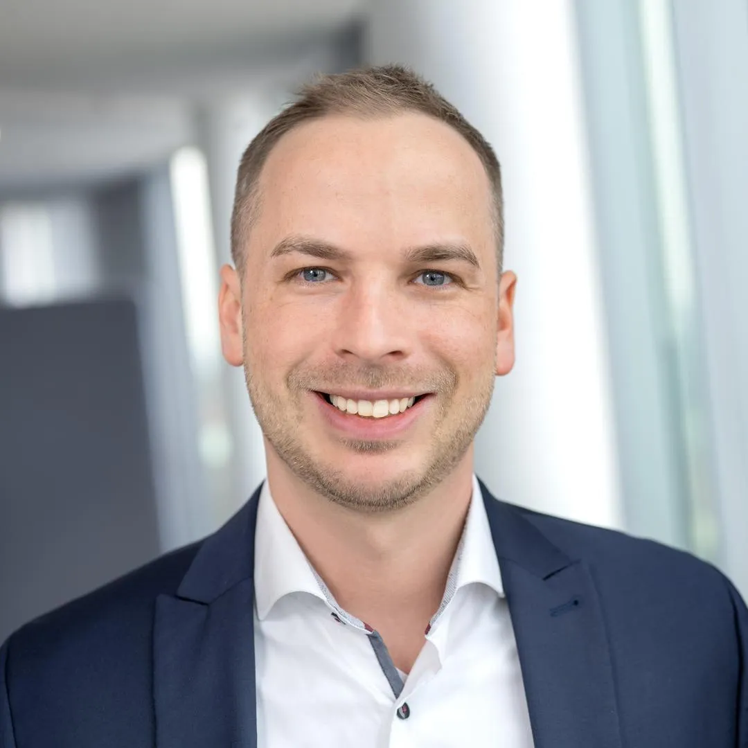 Ein Mann, der in die Kamera lächelt