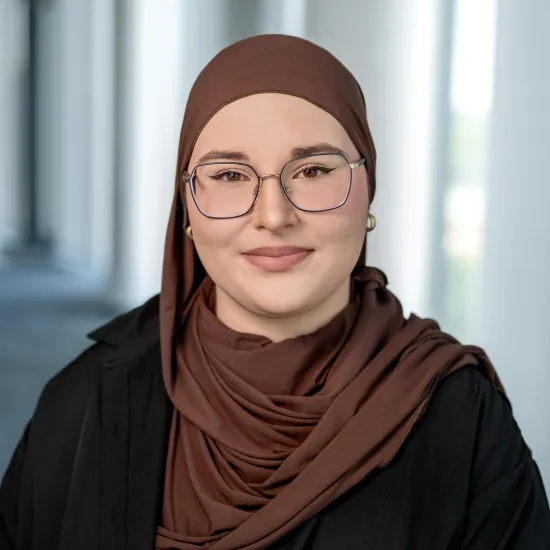 a woman wearing glasses and a brown head scarf