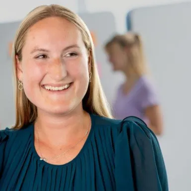 A woman is smiling into a camera.