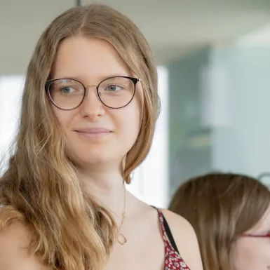 A woman is smiling into a camera.