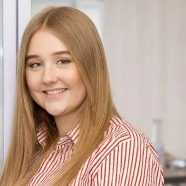 A woman is smiling into a camera.