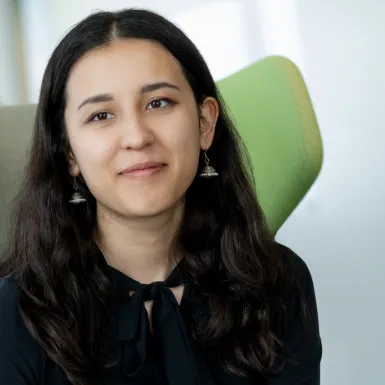 a woman with long hair wearing a black shirt and earrings