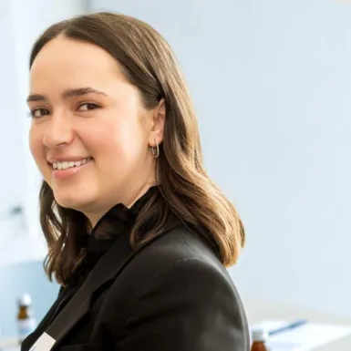 A woman is smiling into a camera.