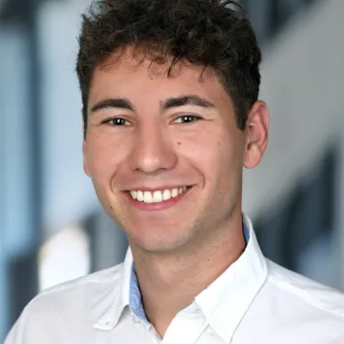 Ein Mann, der in die Kamera lächelt